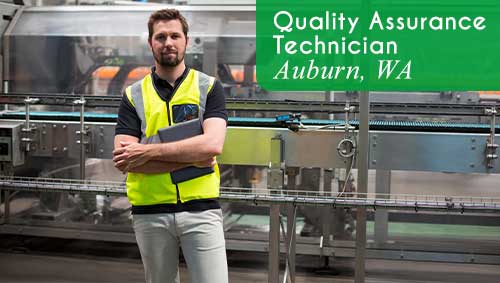 A worker wearing a yellow safety vests with his arms folded is holding a digital notebook and standing in front of machinery in a manufacturing facility. White text over a green banner reads: 'Quality Assurance Technician in Auburn, WA. All StarZ is hiring immediately for this open role.