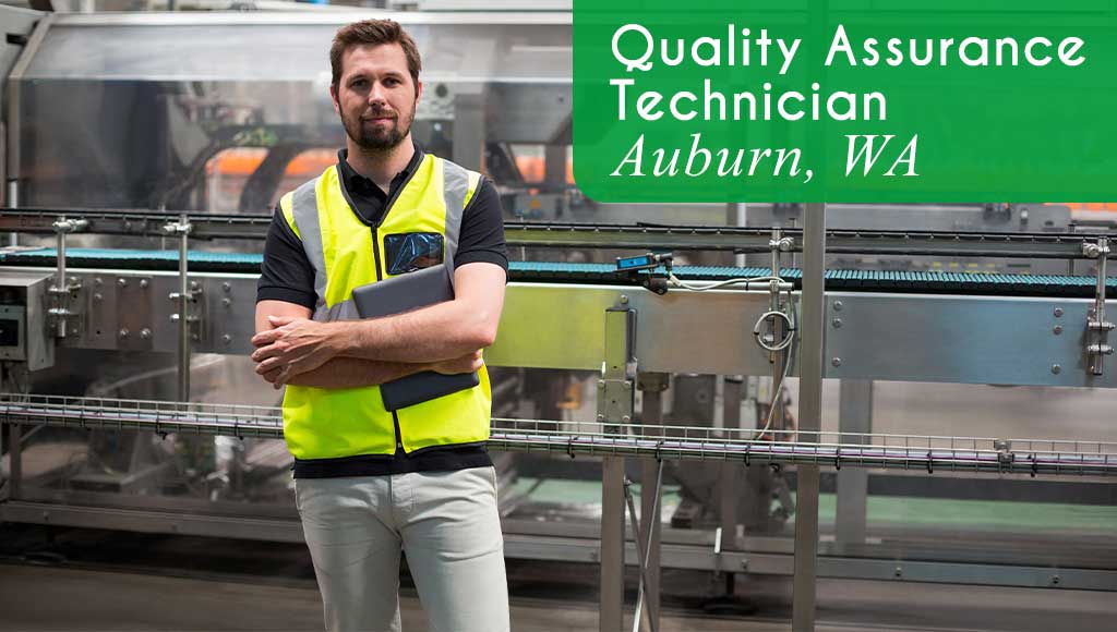 A worker wearing a yellow safety vests with his arms folded is holding a digital notebook and standing in front of machinery in a manufacturing facility. White text over a green banner reads: 'Quality Assurance Technician in Auburn, WA. All StarZ is hiring immediately for this open role.