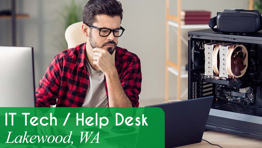 Man working at an IT desk concentrating on a laptop screen. White text over a green banner reads: 'IT / Help Desk in Lakewood, WA.