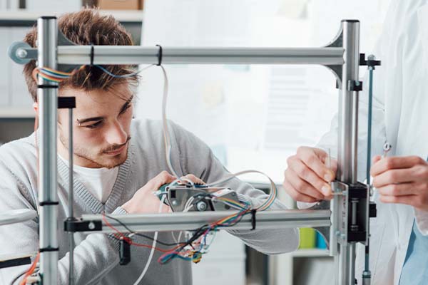 A male worker focuses on fine details in a high-tech manufacturing facility